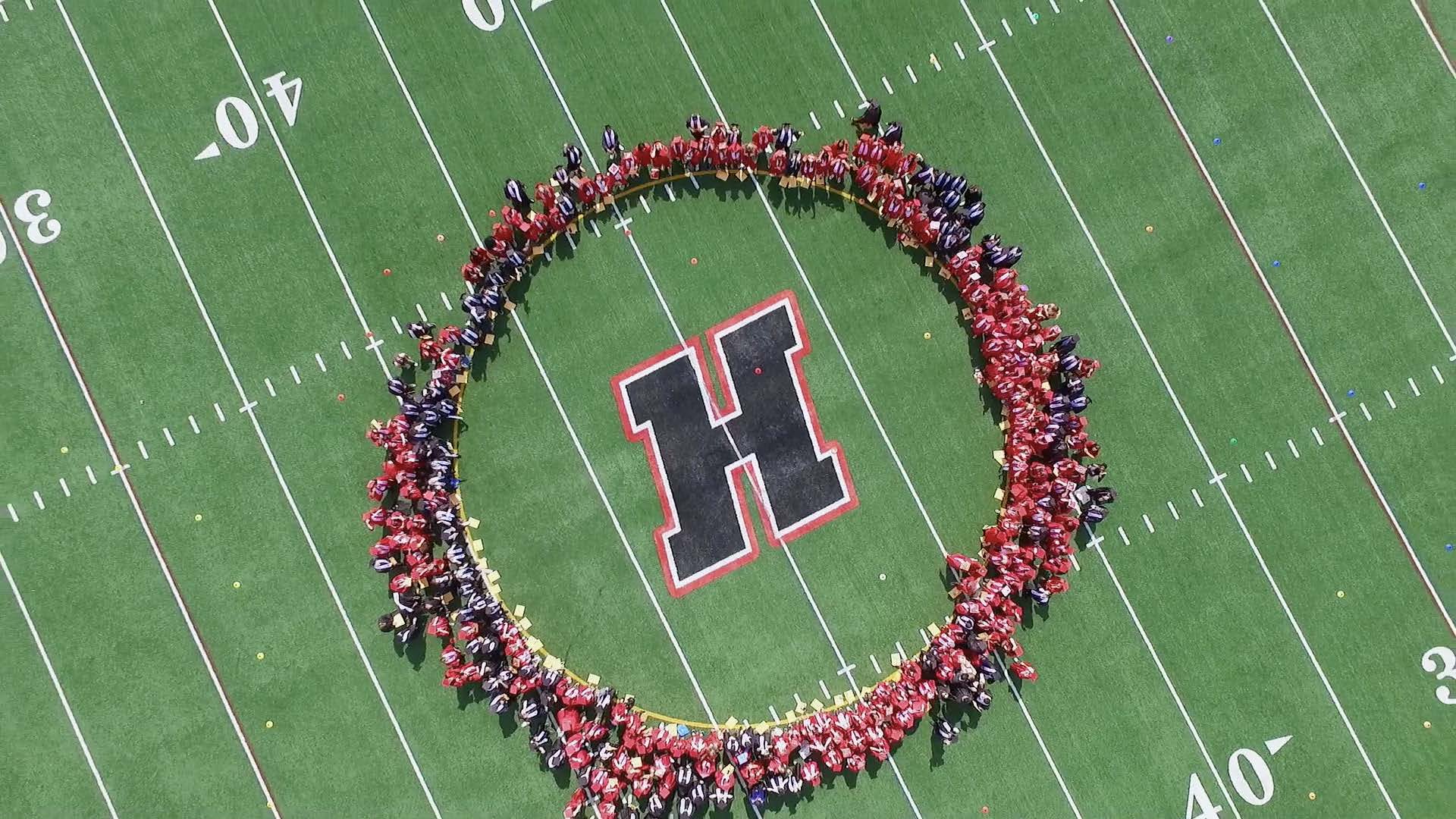 students forming circle on HHS football field